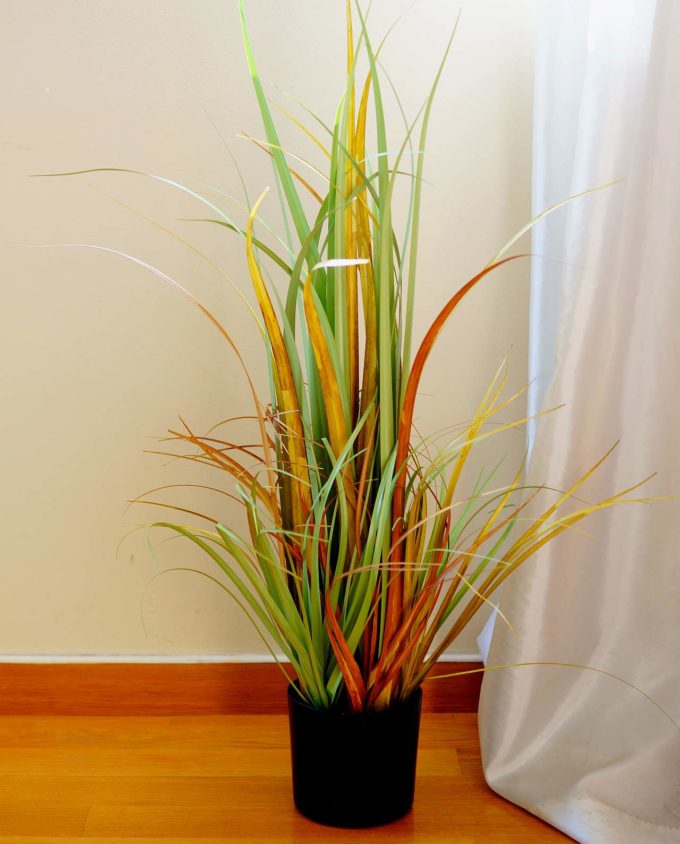 An artificial plant of green-orange leaves in pot to decorate your space, for indoors.